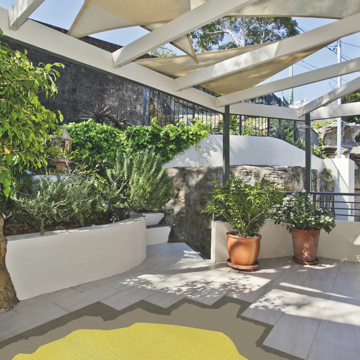 Yellow decoupling mat installed outdoors under tile slabs.