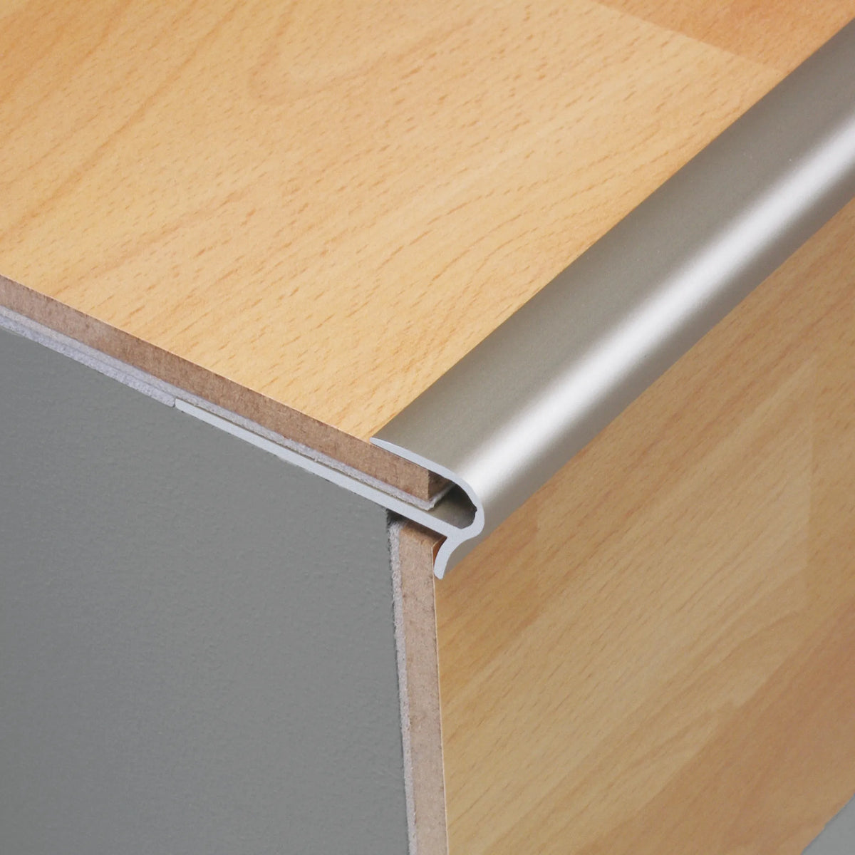 Zdjęcie aranżacyjne profilu wsuwanego do stopni schodowych z aluminium srebrnego matowego zamontowanego z jasnym laminatem