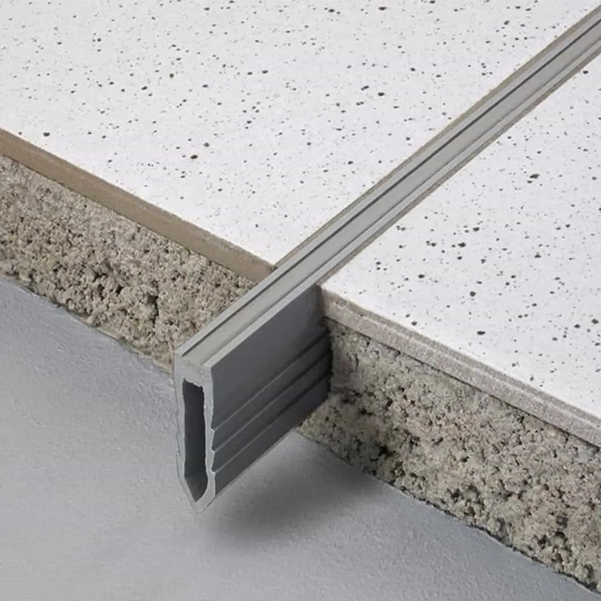 Expansion joint profile made of PVC installed in thick bed. A short piece is not incorporated in the thick bed