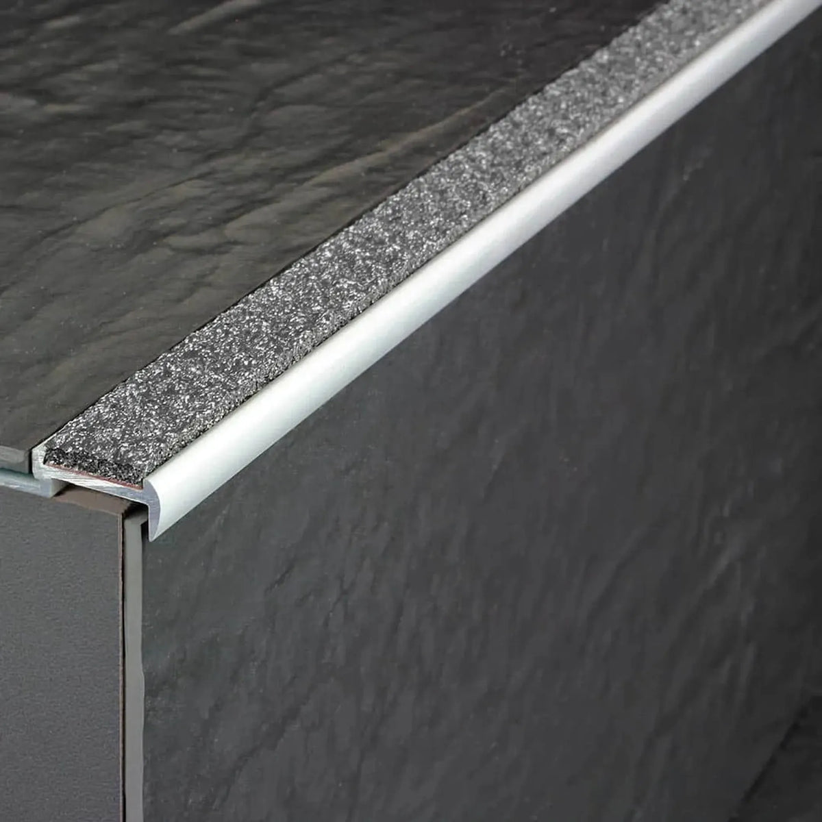 Profilé de nez de marche en aluminium antidérapant posé avec insert anthracite sur une marche carrelée anthracite #A0001729
#A0001734