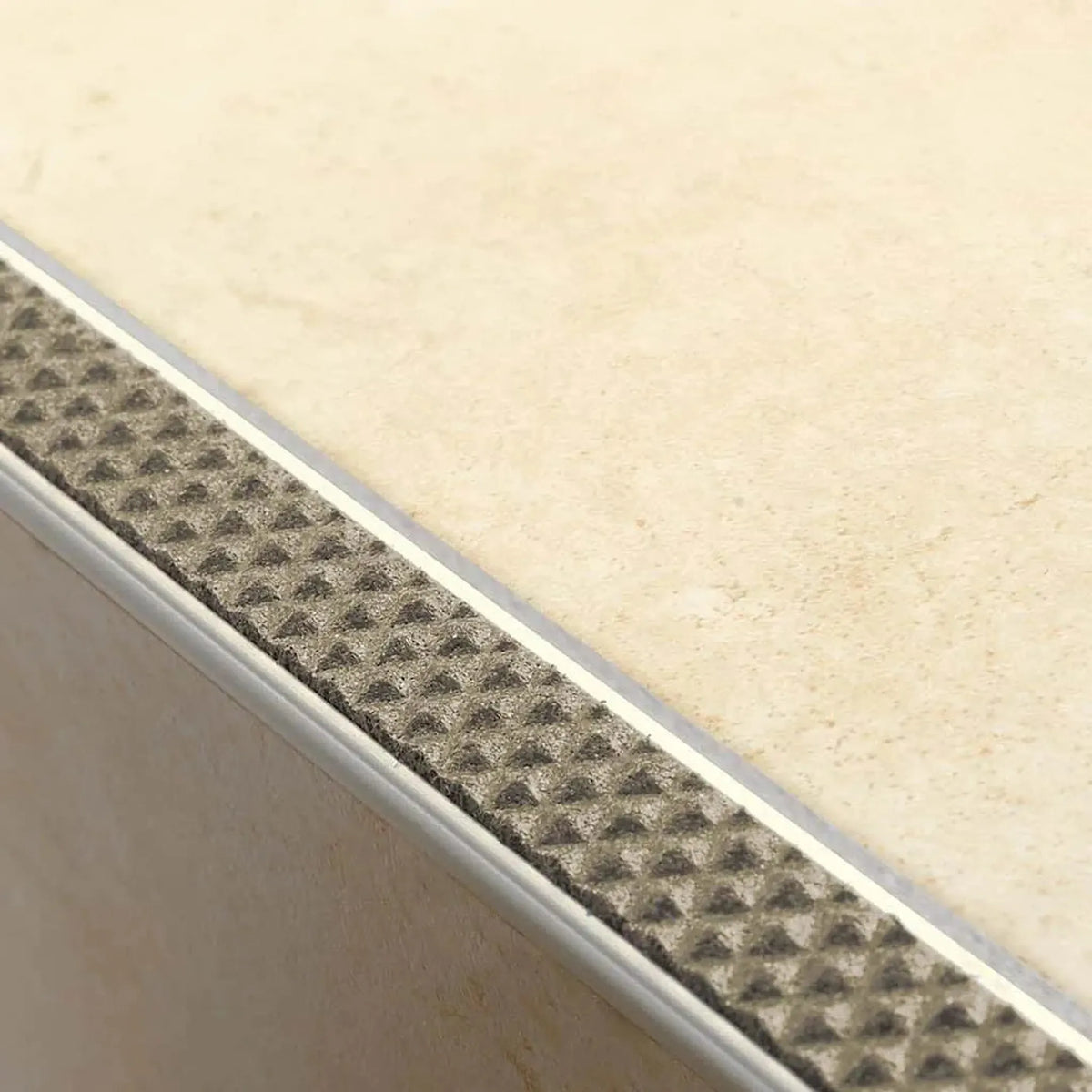 Profilé de nez de marche en aluminium antidérapant posé avec insert sable sur une marche carrelée claire #A0001728
#A0001735