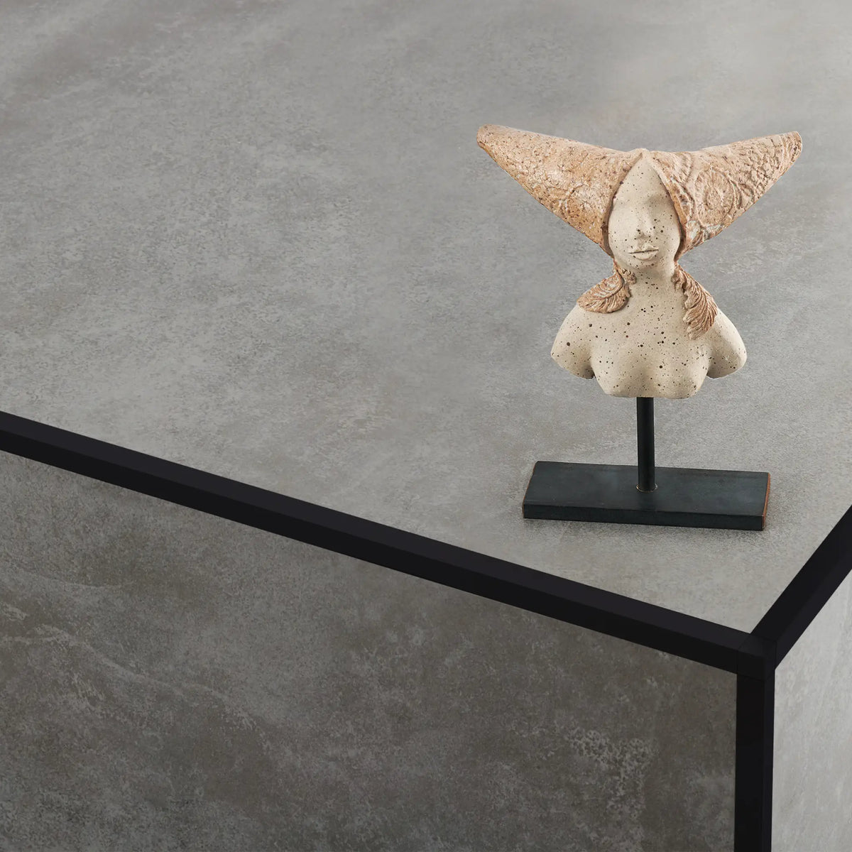 Ambientebild schwarzes Quadratprofil an einer Säule verlegt auf der eine kleine Skulptur steht