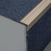 Step profile made of aluminium titanium matt in L-shape with grooved surface on a staircase with carpet #A0005111 #A0005113